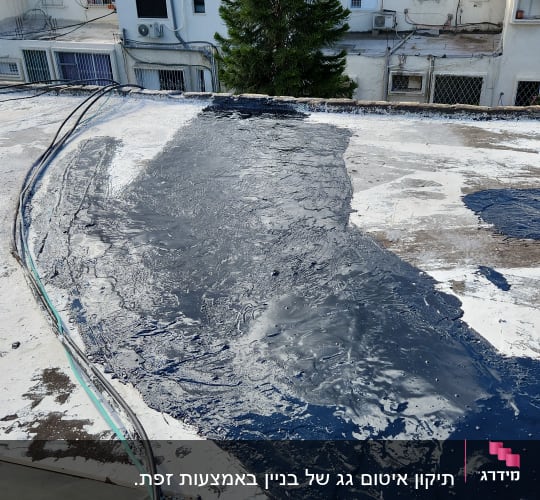 גג עם חומר איטום כהה, כבלים מונחים בצד